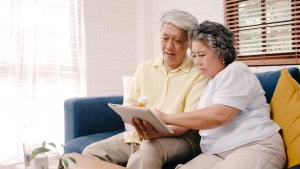 asian elderly couple using tablet search medicine information living room couple using time together while lying sofa when relaxed home